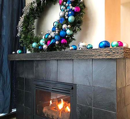 wreath with pink, blue and silver bulbs on fireplace at hotel